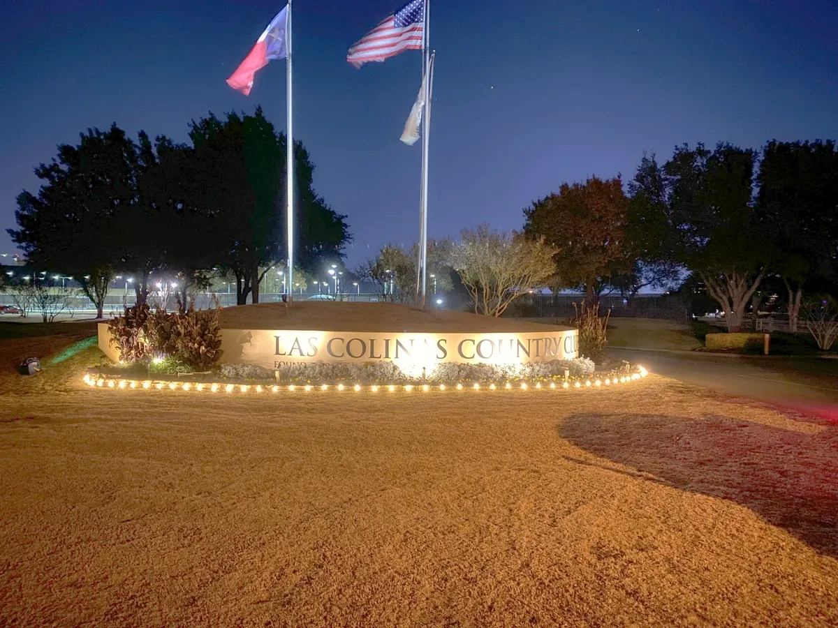 Country club entrance monument and flag display, installed by South Custom Lighting in North Texas
