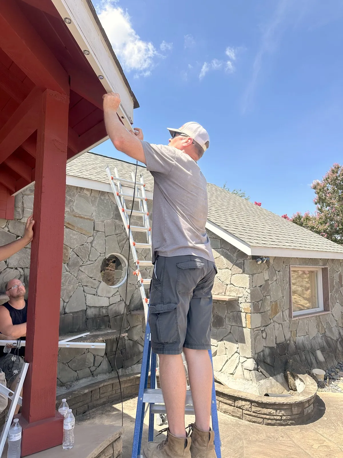Crew on ladders installing at a covered pavilion, installed by South Custom Lighting in North Texas