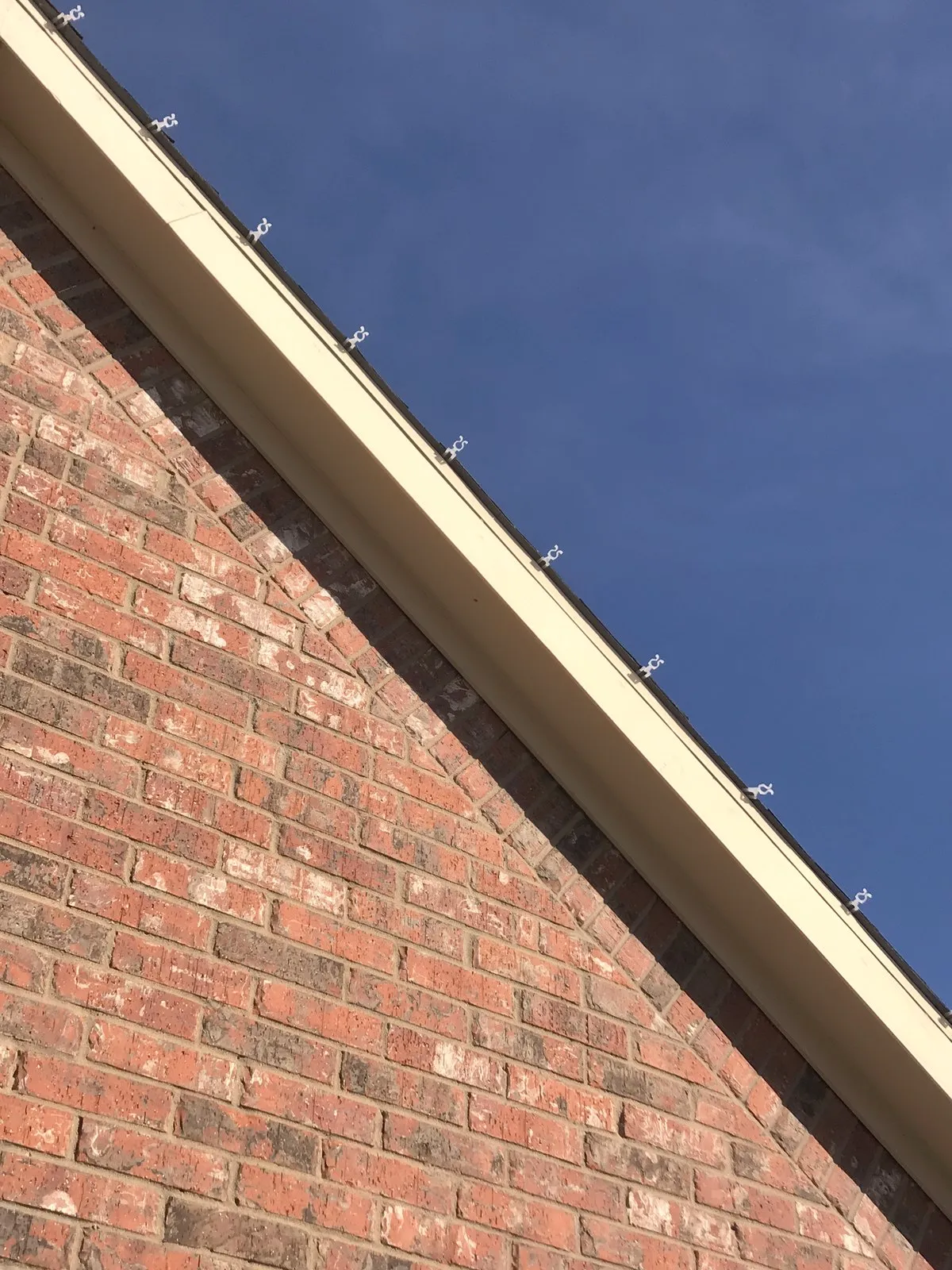 Clip detail on a brick roofline, nothing nailed or stapled, installed by South Custom Lighting in North Texas