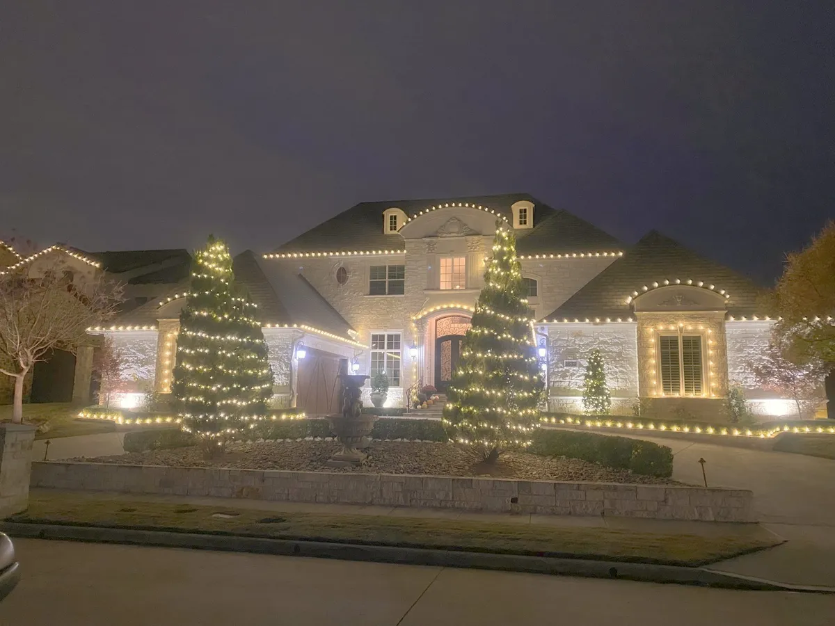 Estate roofline with wrapped trees along the drive, installed by South Custom Lighting in North Texas