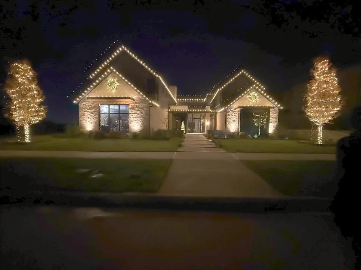 Ranch home at dusk flanked by two lit trees, installed by South Custom Lighting in North Texas