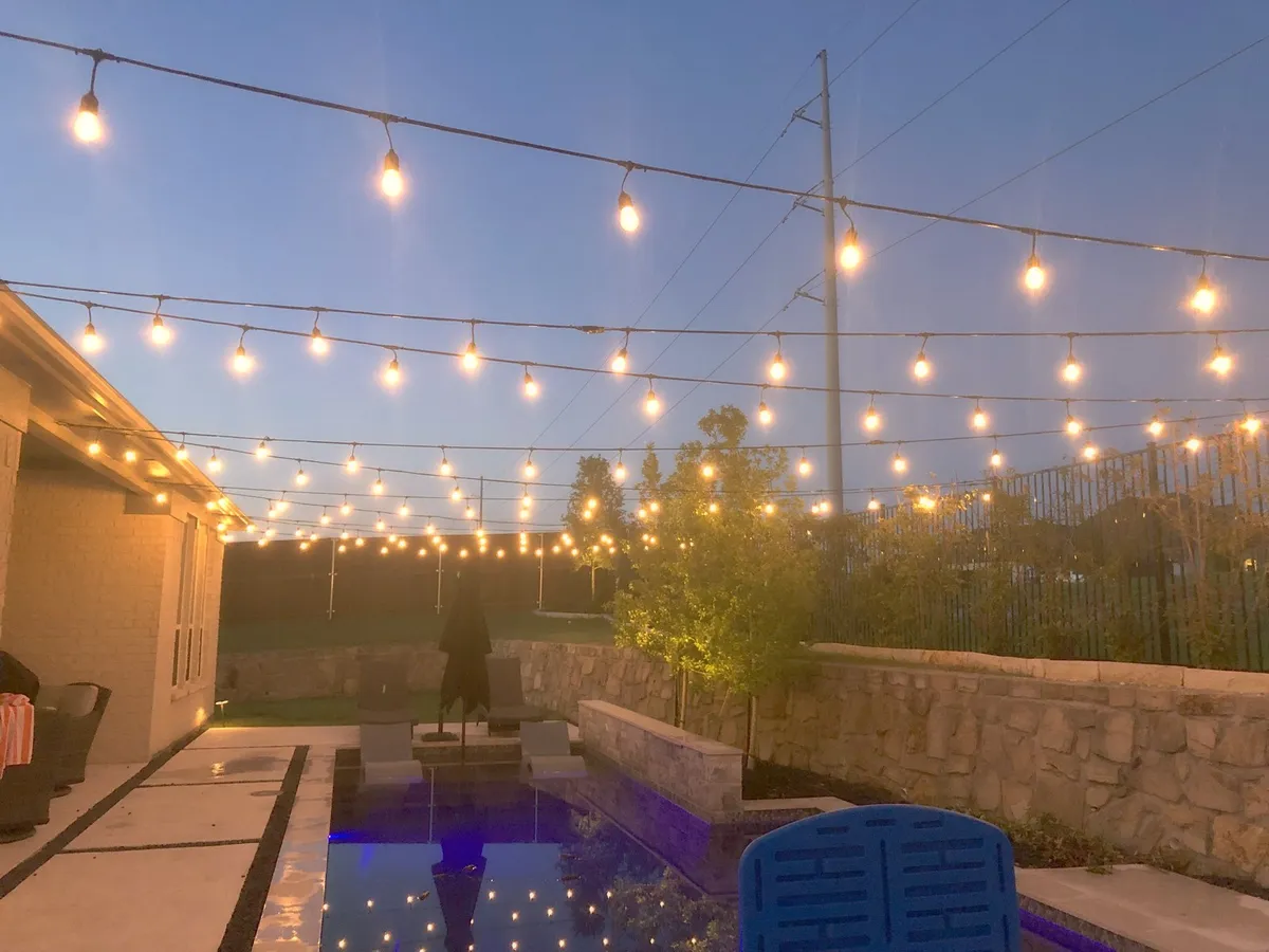 String lighting across a pool deck in the evening, installed by South Custom Lighting in North Texas